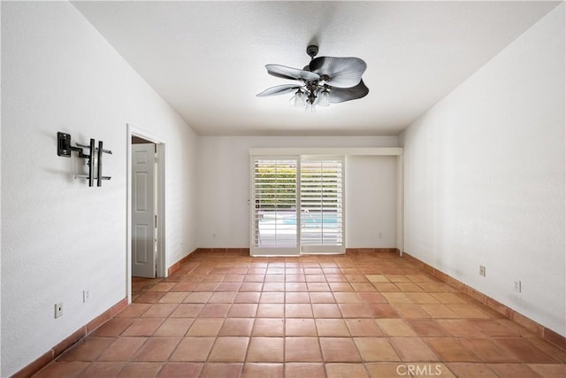 tiled spare room featuring ceiling fan