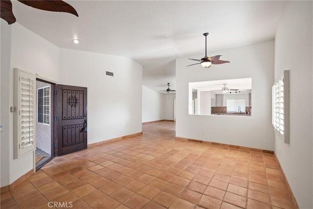 tiled foyer entrance featuring ceiling fan and vaulted ceiling