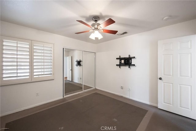 unfurnished bedroom with ceiling fan and a closet