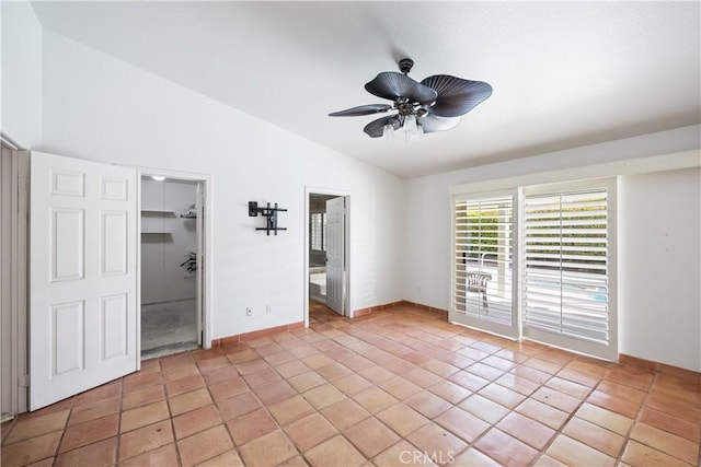 unfurnished bedroom with light tile patterned floors, vaulted ceiling, a closet, and ceiling fan