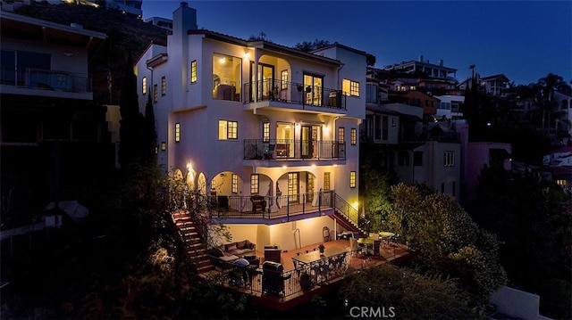 back house at night featuring a balcony