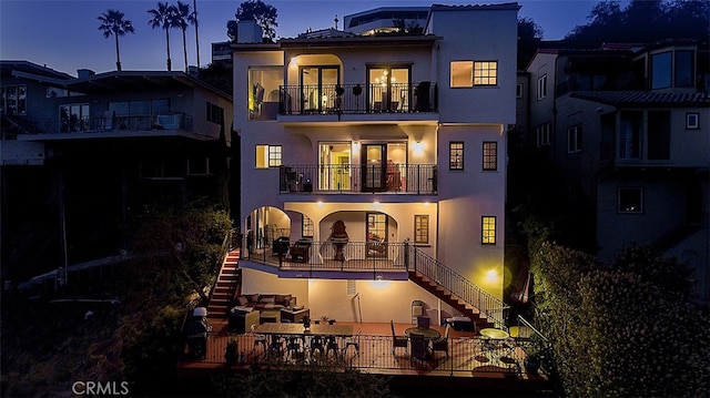 back house at dusk with a balcony