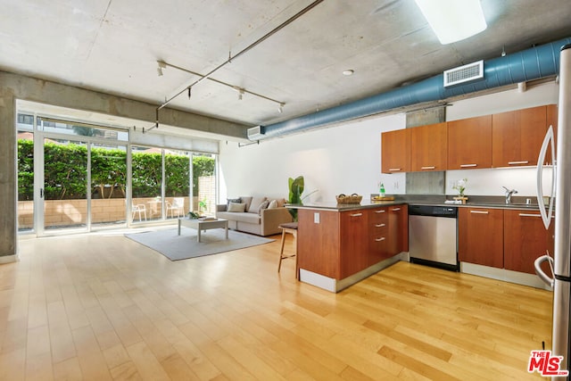 kitchen featuring kitchen peninsula, sink, light wood-type flooring, and appliances with stainless steel finishes