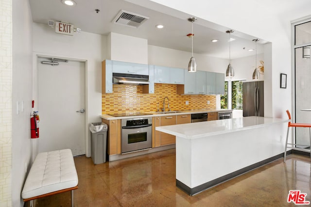 kitchen featuring decorative backsplash, stainless steel appliances, hanging light fixtures, and sink