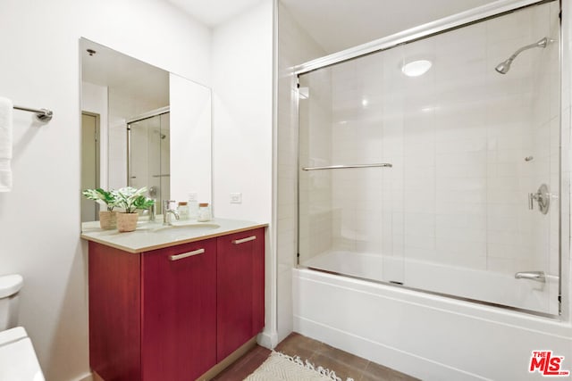 full bathroom featuring tile patterned flooring, vanity, toilet, and enclosed tub / shower combo