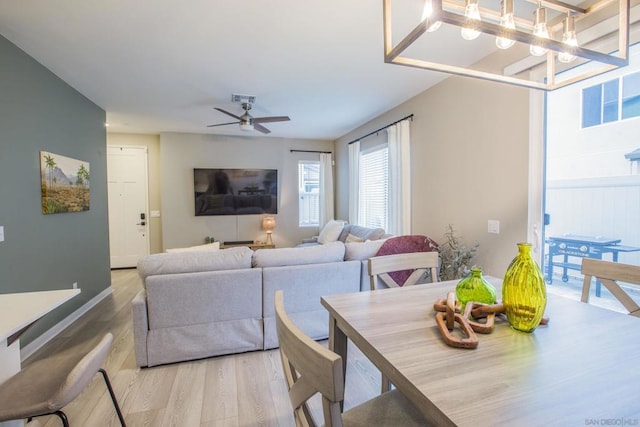 dining area featuring ceiling fan with notable chandelier and light wood-type flooring