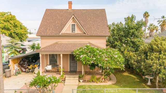 view of front of home with a front yard, a porch, and a carport