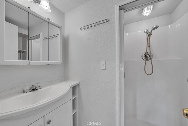 bathroom with vanity and a shower