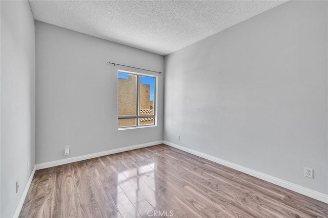 empty room featuring light hardwood / wood-style floors and a textured ceiling