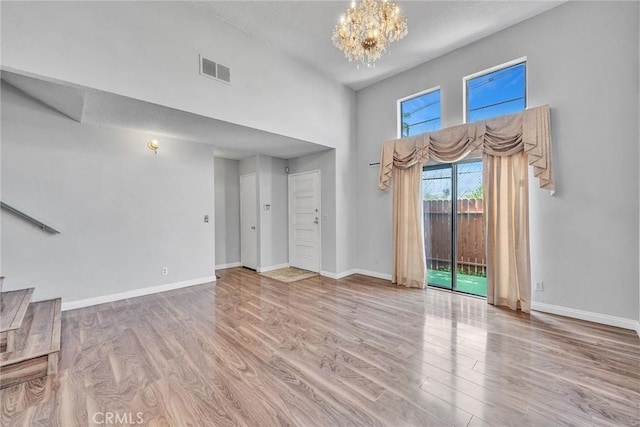 unfurnished living room featuring hardwood / wood-style floors and a notable chandelier