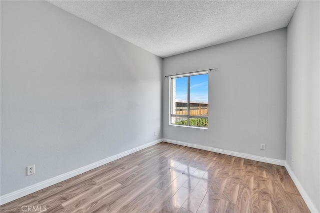 unfurnished room featuring a textured ceiling and light hardwood / wood-style flooring