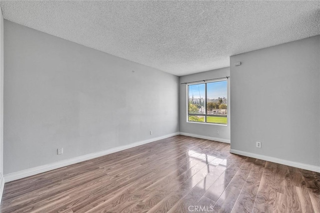 empty room featuring a textured ceiling and wood-type flooring