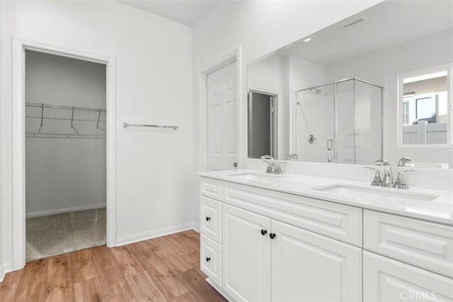 bathroom featuring hardwood / wood-style floors, vanity, and a shower with shower door