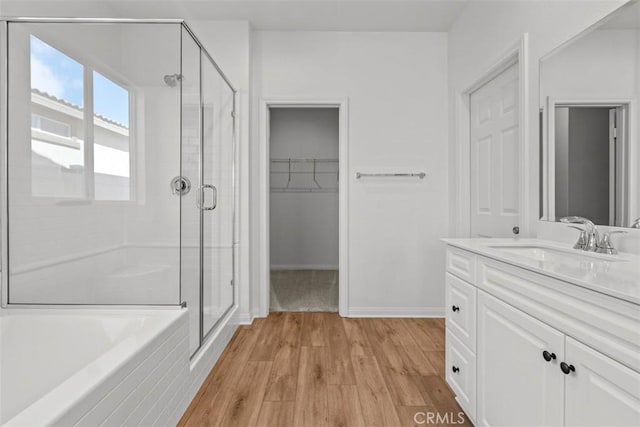 bathroom featuring hardwood / wood-style floors, vanity, and shower with separate bathtub