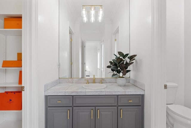 bathroom featuring vanity, crown molding, and toilet