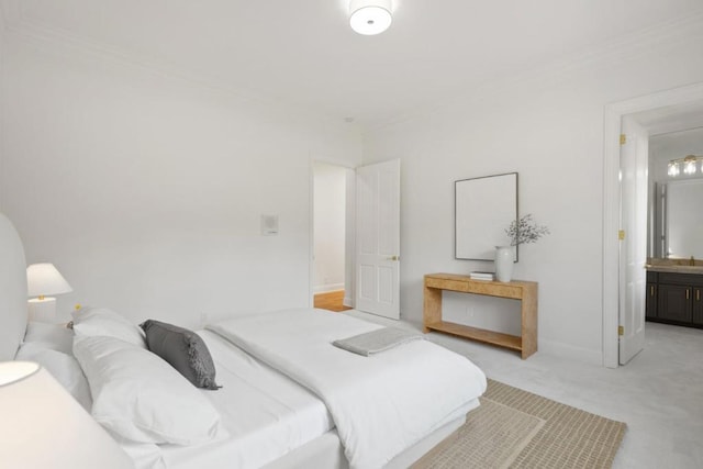 bedroom with light colored carpet, ornamental molding, and connected bathroom