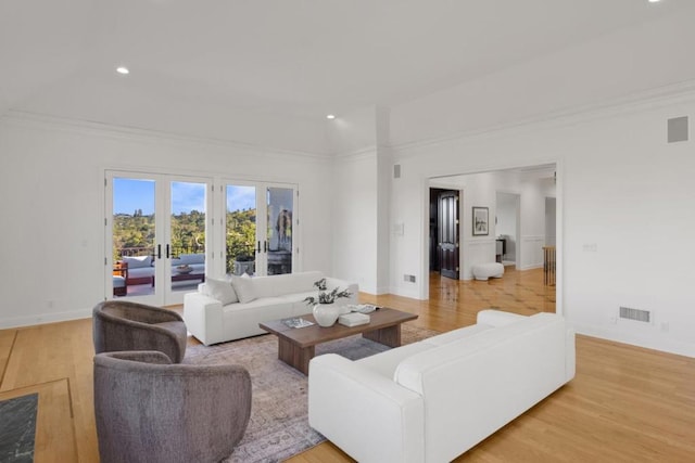 living room featuring ornamental molding, light hardwood / wood-style flooring, and french doors