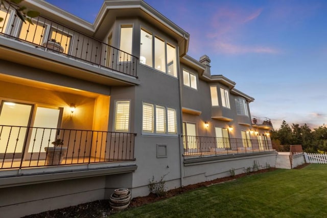 property exterior at dusk featuring a yard