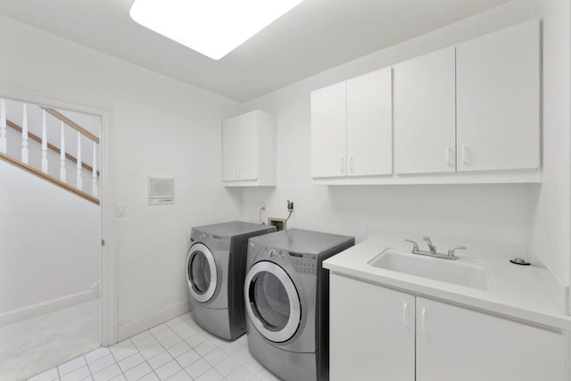 clothes washing area with cabinets, sink, washing machine and dryer, and light tile patterned floors