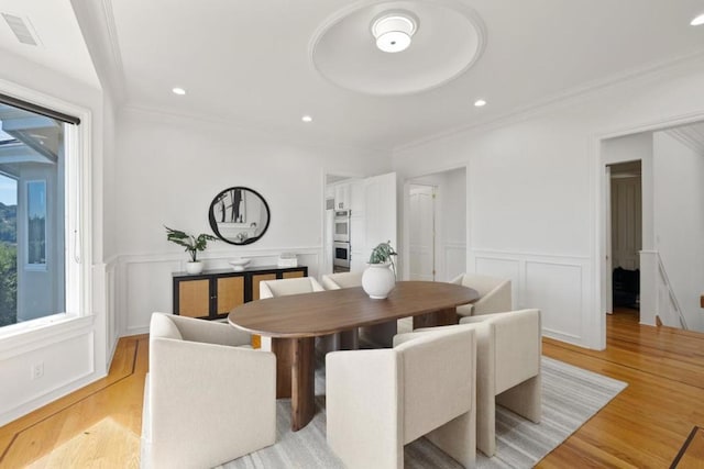 dining room featuring crown molding and light hardwood / wood-style floors