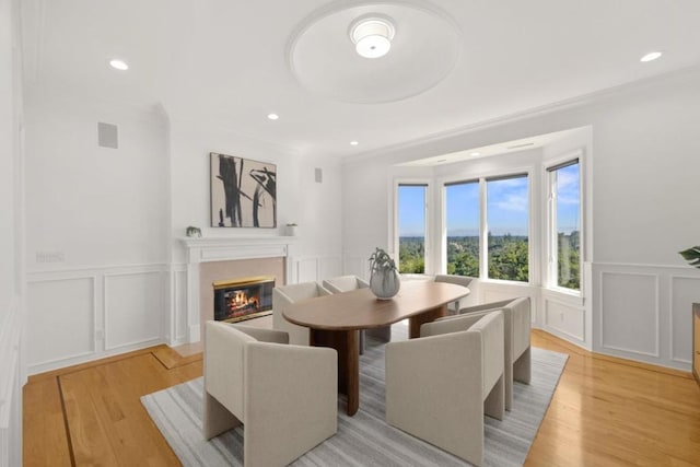 dining room with crown molding and light wood-type flooring