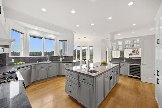 kitchen with beverage cooler, decorative light fixtures, sink, and gray cabinetry