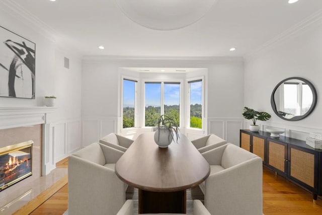 dining area featuring crown molding and light wood-type flooring