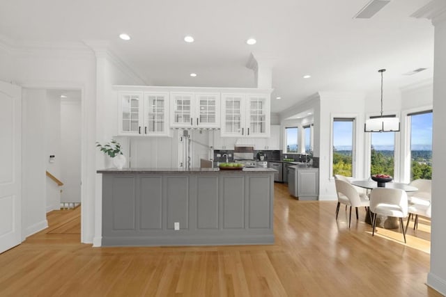 kitchen featuring a wealth of natural light, gray cabinets, hanging light fixtures, and white cabinets