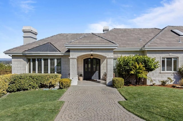 ranch-style home with a front lawn and french doors