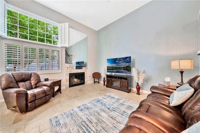 living room featuring high vaulted ceiling and a tile fireplace