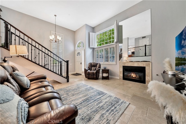 living room with a notable chandelier and a tiled fireplace