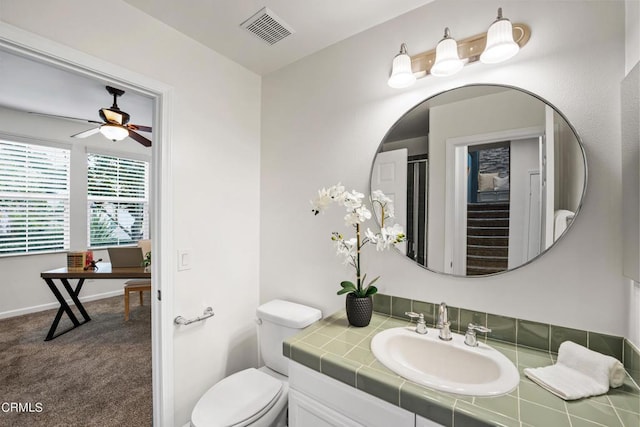 bathroom featuring vanity, toilet, and ceiling fan