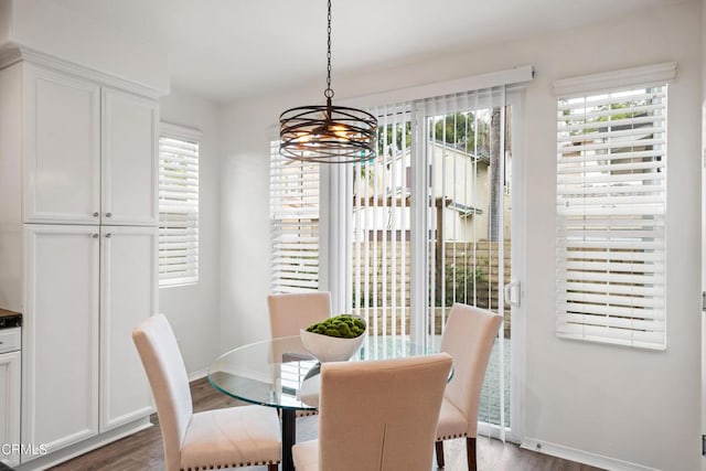 dining area with dark wood-type flooring and a notable chandelier