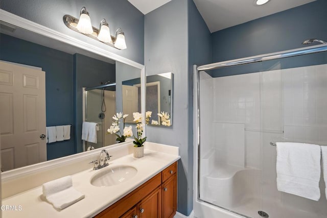 bathroom featuring vanity and a shower with door