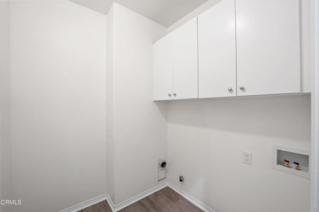 laundry room with hardwood / wood-style floors, hookup for a washing machine, electric dryer hookup, and cabinets