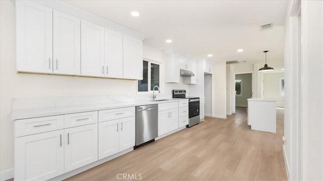 kitchen featuring white cabinets, hanging light fixtures, sink, appliances with stainless steel finishes, and light hardwood / wood-style floors