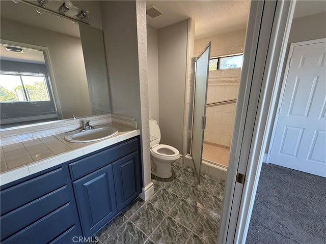 bathroom with vanity, toilet, and an enclosed shower