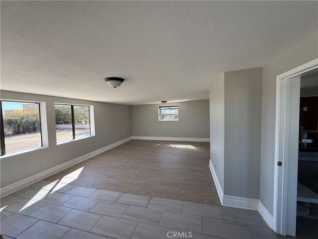 spare room featuring light wood-type flooring and a textured ceiling