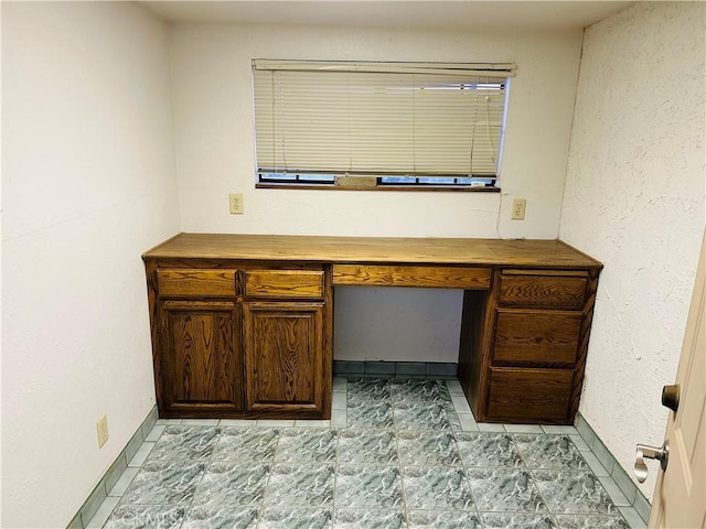 unfurnished office featuring built in desk