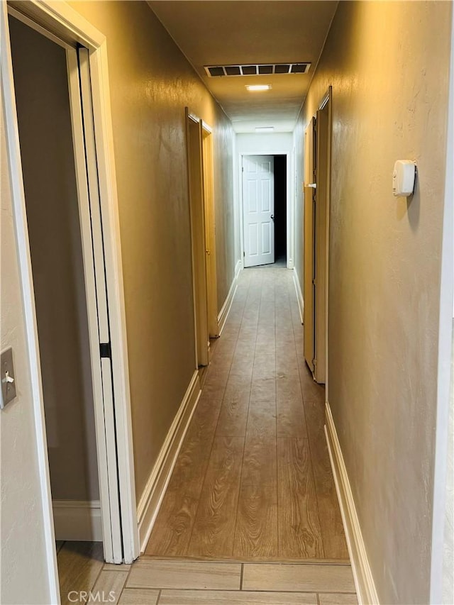 corridor with light hardwood / wood-style floors