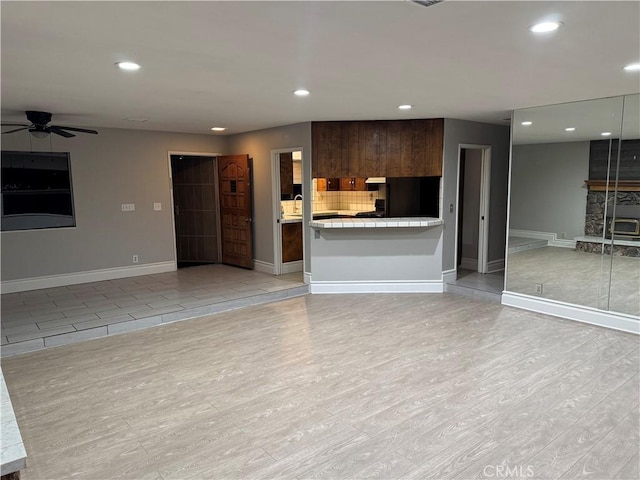 unfurnished living room with ceiling fan and light hardwood / wood-style floors