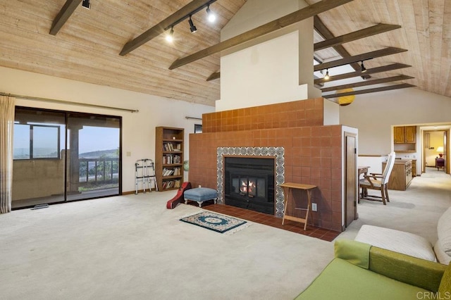 carpeted living room with wood ceiling, rail lighting, a fireplace, high vaulted ceiling, and beam ceiling