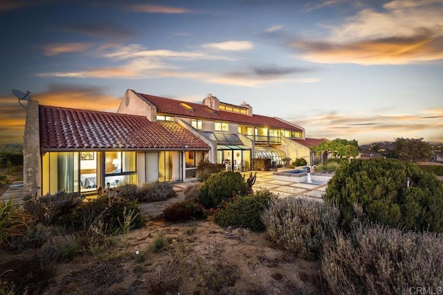 back house at dusk with a patio