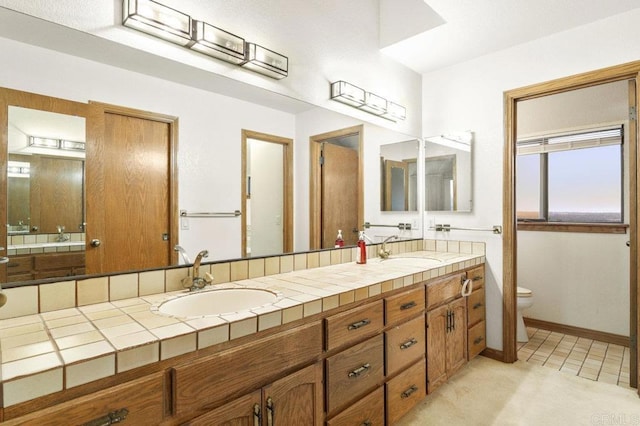 bathroom featuring toilet, tile patterned flooring, and vanity