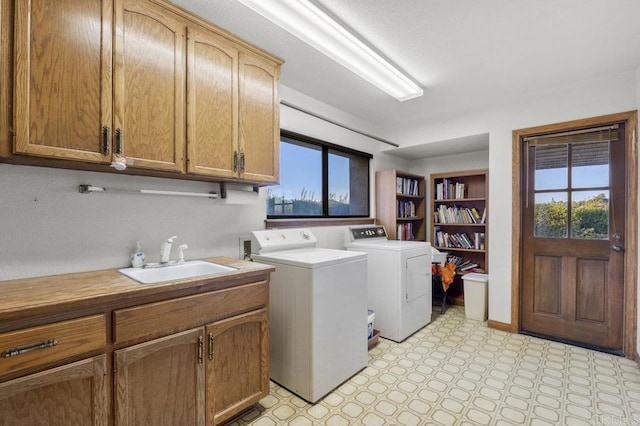 laundry area featuring cabinets, sink, and separate washer and dryer