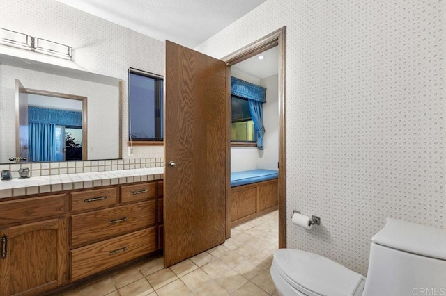 bathroom featuring toilet, tile patterned flooring, and vanity