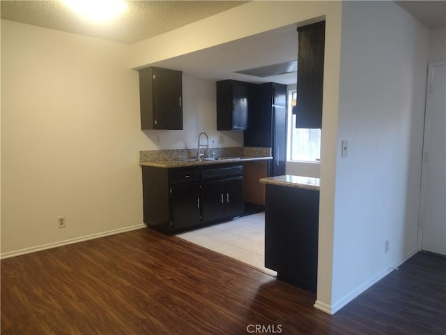 kitchen featuring sink, a textured ceiling, and light wood-type flooring