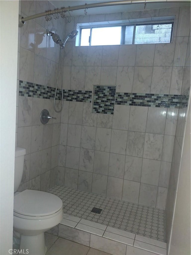 bathroom with tiled shower and toilet