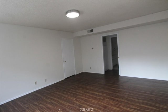 unfurnished room featuring dark wood-type flooring