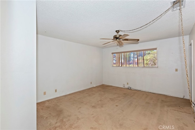 spare room featuring ceiling fan, a textured ceiling, and light carpet